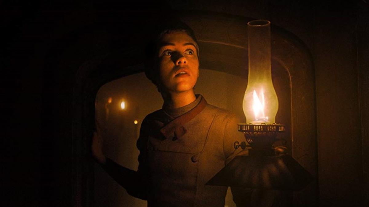 Gretel (Sophia Lillis) investigates the witch's house by lamplight in Osgood Perkins' 'Gretel & Hansel'.