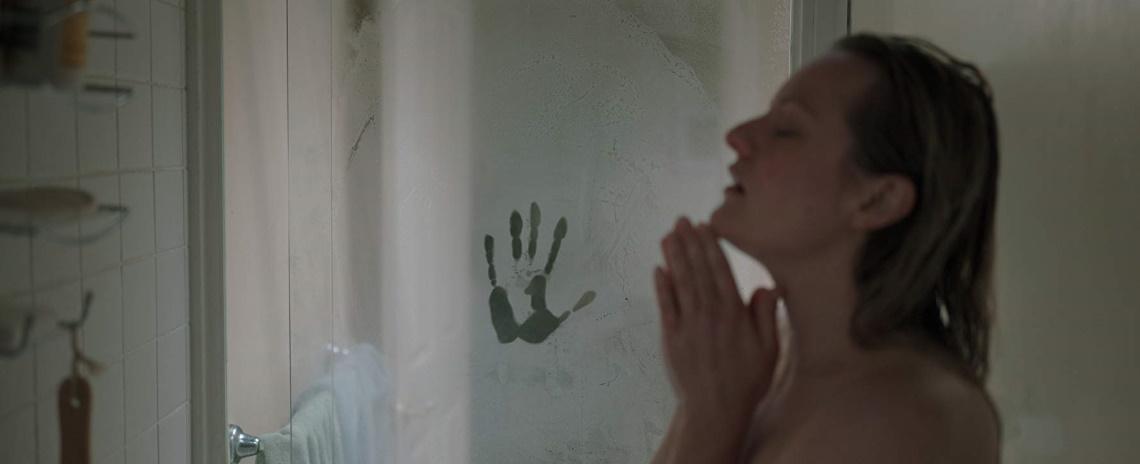 Cecilia Kass (Elizabeth Moss) showers, unaware of the ghostly handprint on the glass shower door, in Leigh Whannell's 'The Invisible Man'.